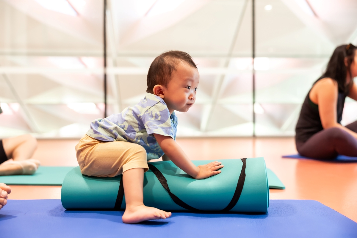 baby boy sitting on yoga mat