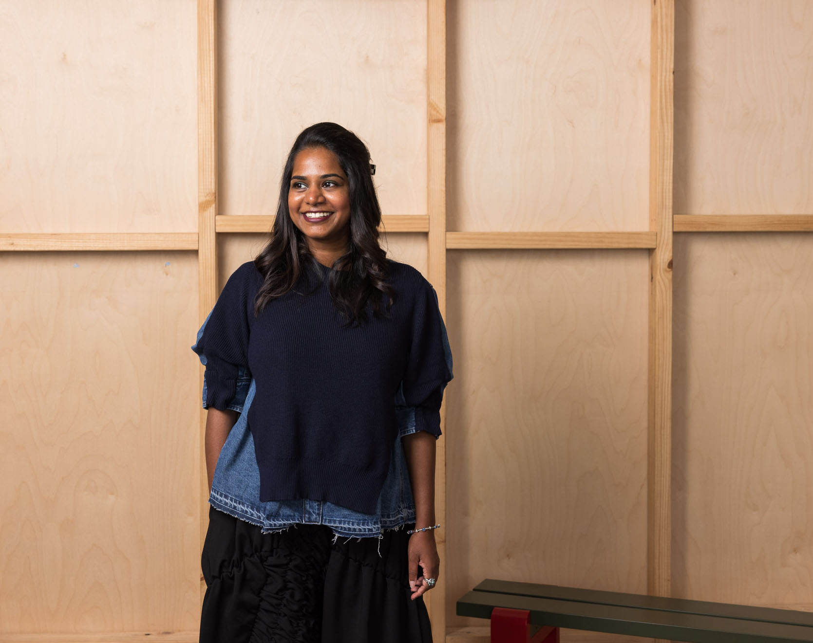 Person standing against a wooden backdrop