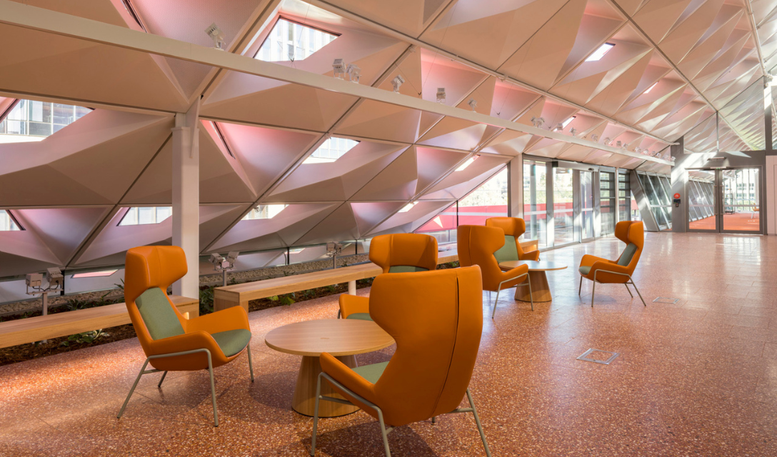 Room with slanted roof and orange arm chairs