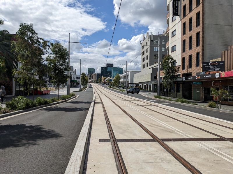 Road with rail tracks and shops are on the side