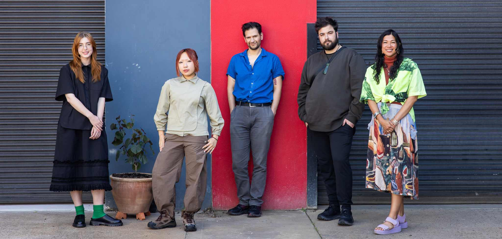 A group of people gathered in front of a two toned wall